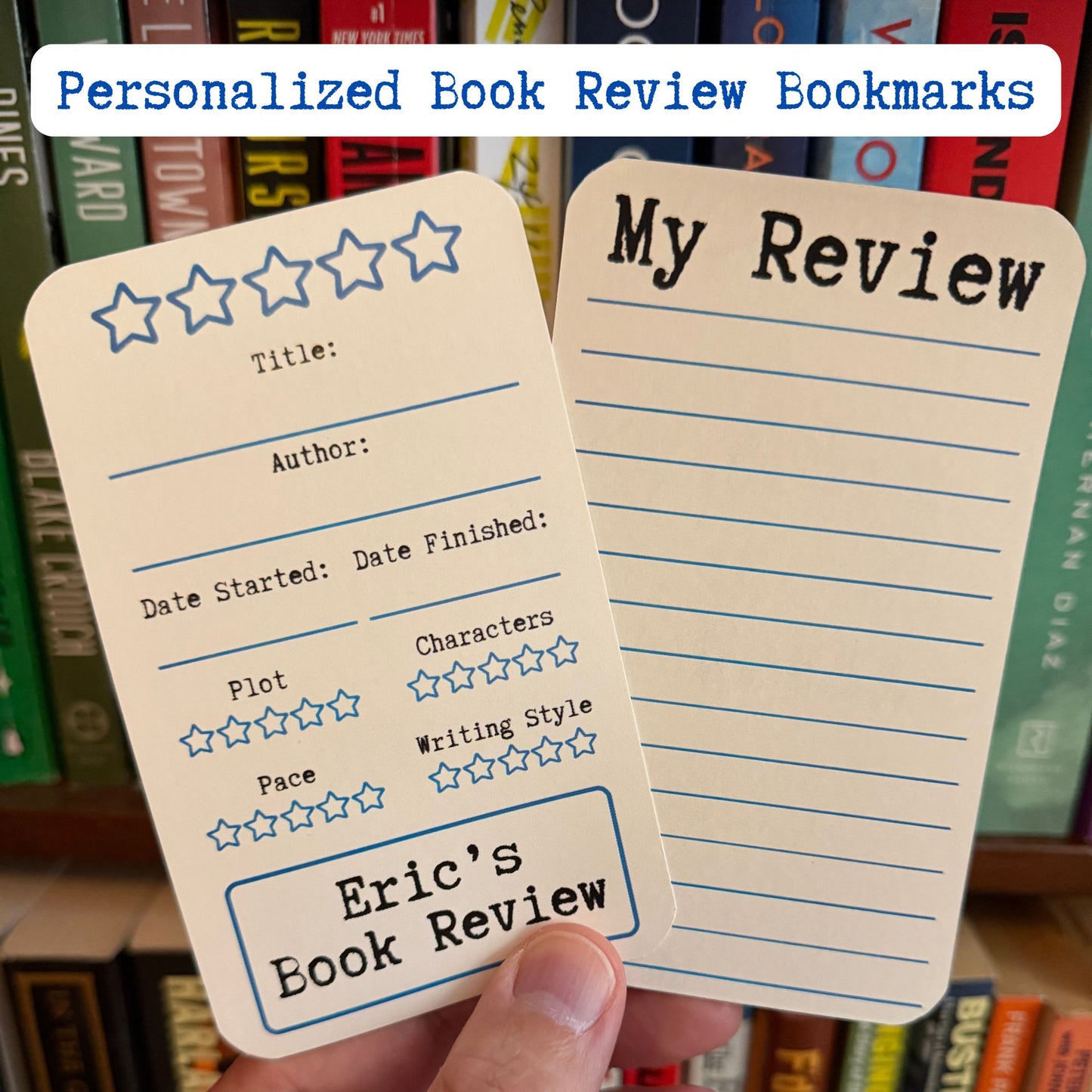 Two personalized book review bookmarks are held in a hand in front of a bookshelf. One bookmark is a cream card with blue star ratings and text fields for title, author, dates, and review scores, personalized to 'Eric's Book Review'.